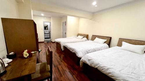 una habitación con 2 camas y una mesa con flores en Bhaktapur City Hotel en Bhaktapur