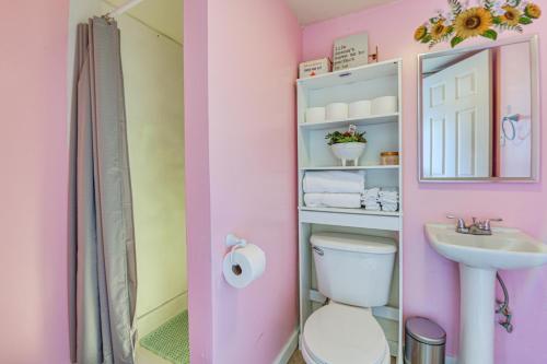 a pink bathroom with a toilet and a sink at Fort Walton Beach Studio Shared Pool and Beach Bar! in Fort Walton Beach