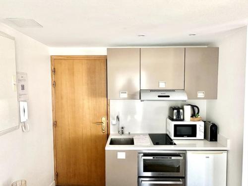 une petite cuisine avec un micro-ondes et une cuisinière dans l'établissement Paris, Opéra 5...Charming apartment in Paris, à Paris