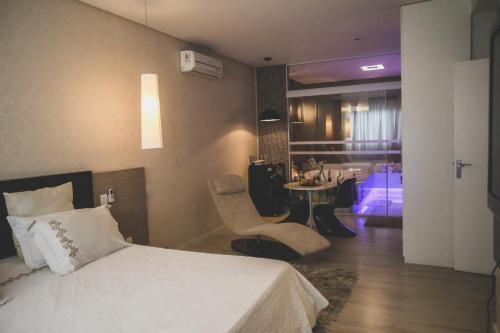 um quarto de hotel com uma cama e uma sala de jantar em Gontijo Inn Hotel em Itajubá