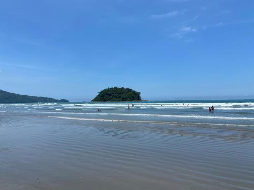 a beach with people swimming in the ocean at Kaliman Pousada in Ubatuba