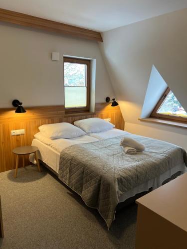 a bedroom with a bed and a window at Rozetka in Białka Tatrzańska