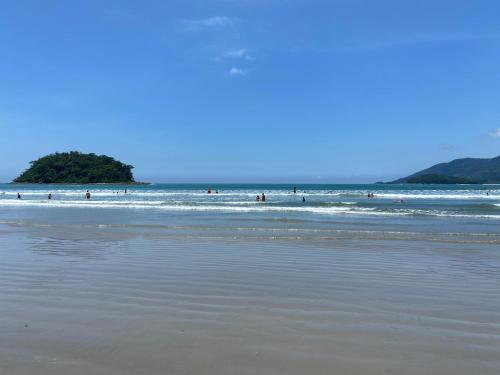 un grupo de personas en el agua en la playa en Kaliman Pousada, en Ubatuba