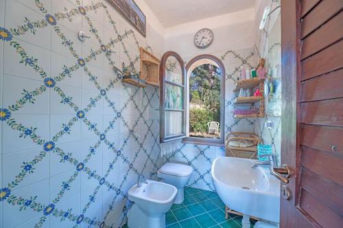 a bathroom with a sink and a toilet and a window at Le Tortore - Villetta vista mare in Magazzini