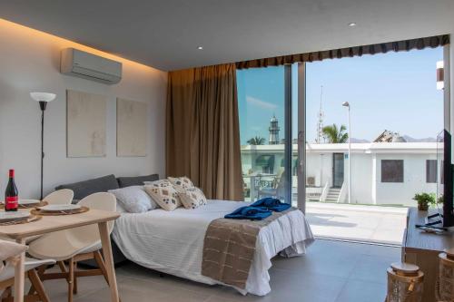 a bedroom with a bed and a table and a balcony at Amor A Mar Dolphin in Puerto del Carmen