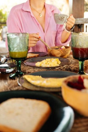 a woman is sitting at a table with food at Hani Hideaway in Gili Air