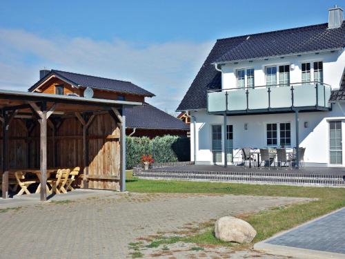 a house with a pavilion next to a building at Feldstrasse 3 b in Zempin