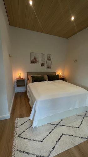 a bedroom with a large white bed with two lamps at Cozy Apartment Blume in Hagen