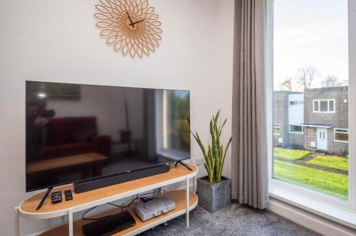 uma sala de estar com uma grande televisão de ecrã plano em 2 bed spacious, light & quiet flat, free parking em Heaton