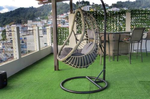 a swing on a balcony with a view of a city at Apto Vista Hermosa con terraza ajardinada privada in Sololá
