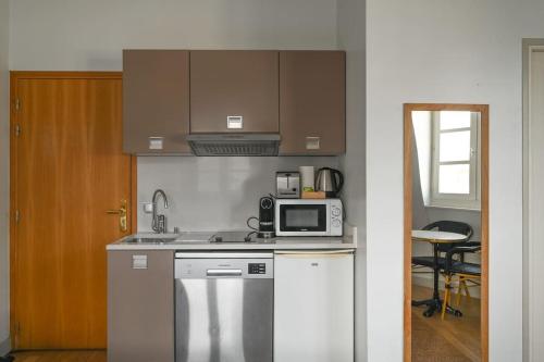 une cuisine avec une cuisinière et un micro-ondes dans l'établissement Paris, Opéra 6...une balade romantique, à Paris