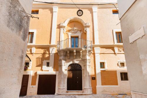a building with a balcony and a clock on it at Palazzo De Luca by Apulia Hospitality in Fasano