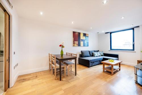 a living room with a couch and a table at Modern Paddington Station 2 Bedroom Apartment in London