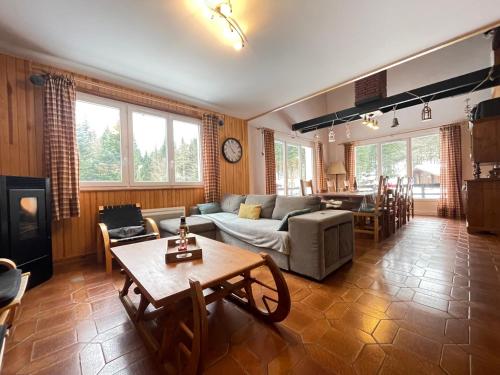 un salon avec un canapé et une table dans l'établissement CHALET DES HAUTS SAPINS LA BRESSE, à La Bresse