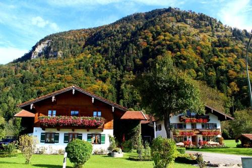 a large house in front of a mountain at Schusterhof in Marquartstein