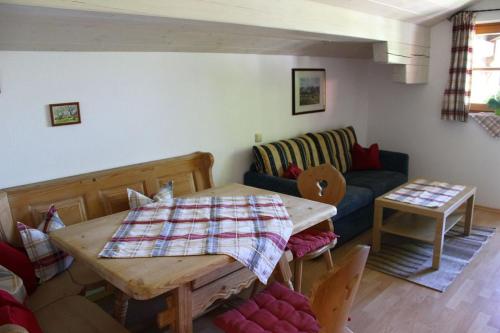 a living room with a table and a couch at Schusterhof in Marquartstein