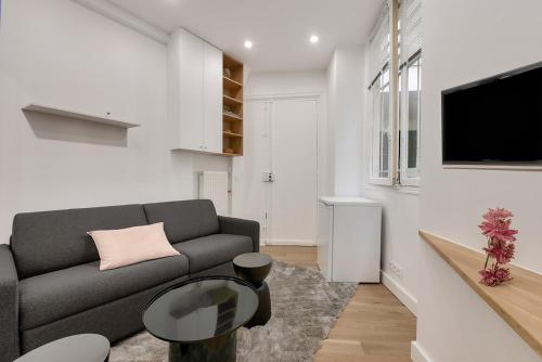 un salon avec un canapé et une télévision dans l'établissement 165 - Urban Studio near Haussmann Boulevard, à Paris