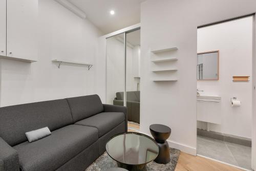 un salon avec un canapé et une table en verre dans l'établissement 165 - Urban Studio near Haussmann Boulevard, à Paris