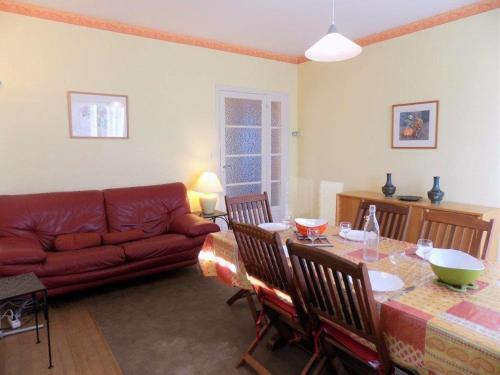 un salon avec une table et un canapé rouge dans l'établissement Saint Georges de Didonne - MAISON à proximité du centre et de la plage, à Saint-Georges-de-Didonne