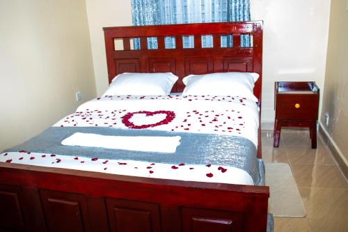 Una cama con una decoración de corazón rojo. en Lavish Haven Home, en Bungoma