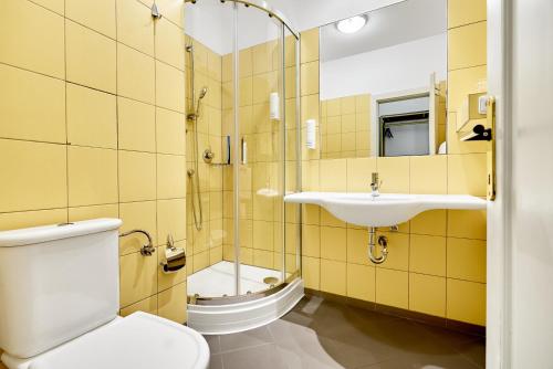 La salle de bains est pourvue de toilettes et d'un lavabo. dans l'établissement Hotel Maxim, à Mariánské Lázně