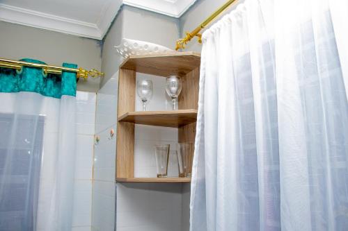 y baño con ducha y cortina de ducha. en Lavish Haven Home, en Bungoma