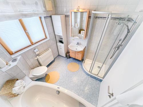 a bathroom with a tub and a toilet and a sink at Goldberg-Aparts in Rauris