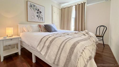 a bedroom with a bed with a table and a chair at Fremantle High Street Retreat in Fremantle