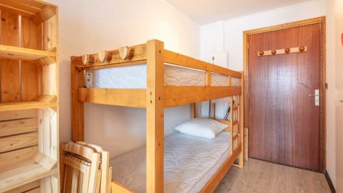 een slaapkamer met 2 stapelbedden en een deur bij LE VERNON 1027 Appt premium 4 pers in Chamrousse