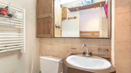 een badkamer met een toilet, een wastafel en een spiegel bij LE VERNON 1027 Appt premium 4 pers in Chamrousse