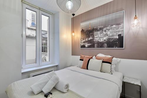 Residence Tour Eiffel by Studio prestige في باريس: غرفة نوم بسرير ابيض ونوافذ