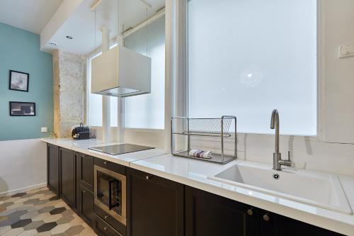 une cuisine avec un évier et une grande fenêtre dans l'établissement Residence Tour Eiffel by Studio prestige, à Paris