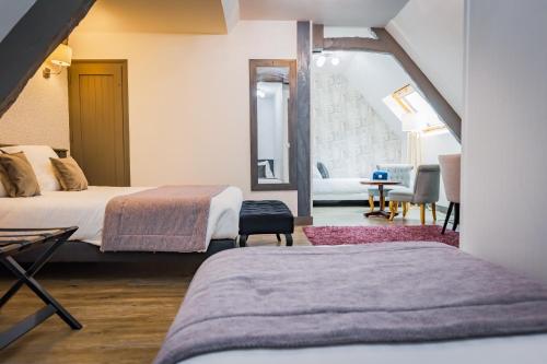 une chambre avec deux lits et un salon dans l'établissement Grand Hôtel du Luxembourg & Spa, à Bayeux