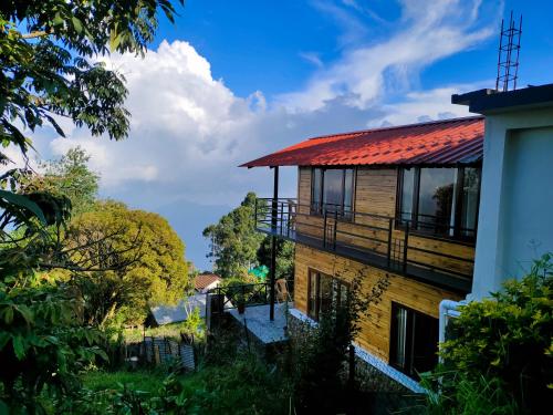 a house with a red roof and a balcony at MISBHA HomeStay in Kodaikānāl