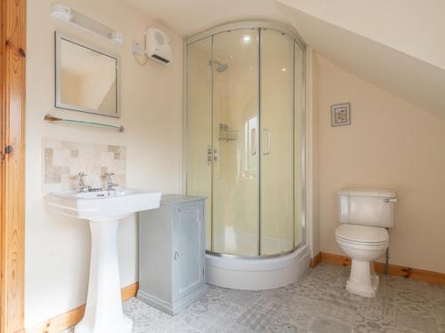 a bathroom with a shower and a sink and a toilet at Blacksmith's Cottage in Tobermory