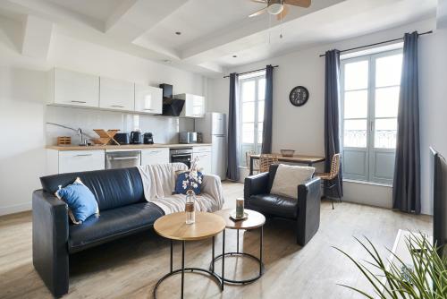 ein Wohnzimmer mit einem Sofa und einem Tisch in der Unterkunft Paul Riquet 1609 City Center Residences in Béziers