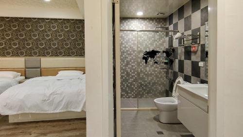 1 dormitorio con cama, aseo y lavamanos en Dong Yong Travel, en Dongyin/