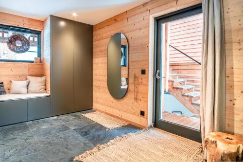 Cette chambre est dotée de murs en bois et d'une porte avec fenêtre. dans l'établissement Chalet Sia - Contemporain - Sauna prive, à Chamonix-Mont-Blanc