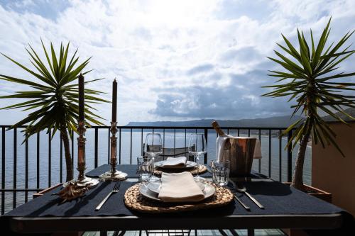 a table on a balcony with a view of the water at Casa Isola in Bergeggi