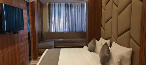 une chambre d'hôtel avec un lit et un canapé dans l'établissement HOTEL GOLDEN PEACOCK, à Haridwar