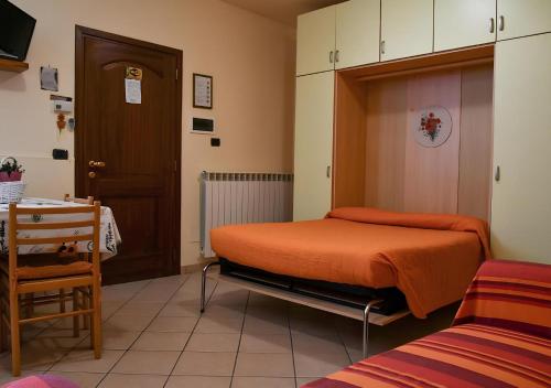 a bedroom with a bed with an orange bedspread at Gli Angeli Agriturismo - Zia Rosa in Cisano sul Neva