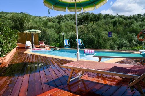 einen Pool mit einem Tisch und einem Sonnenschirm in der Unterkunft Gli Angeli Nonna Erminia e Vittorio in Cisano sul Neva