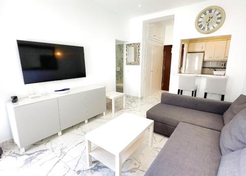 uma sala de estar com um sofá e uma televisão em SKOL 424 Stunning One-bedroom apartment with sea views em Marbella