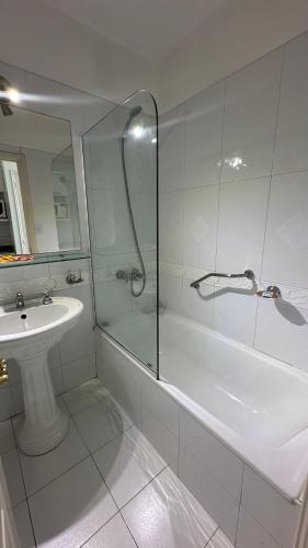 un bagno bianco con doccia e lavandino di Apartamento Millennium inn a Mendoza