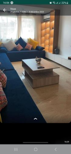 Sala de estar con sofá azul y mesa de centro en Hyper centre, en Marrakech