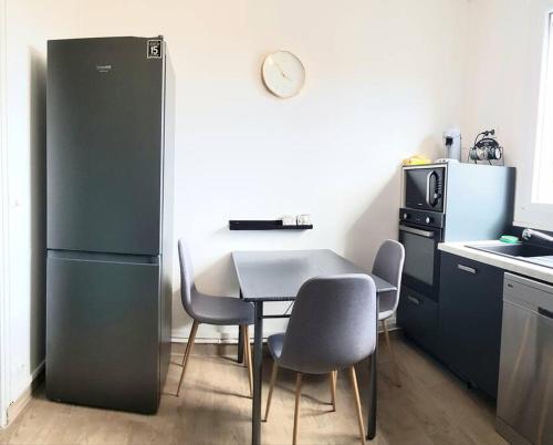 eine Küche mit Tisch und Stühlen und einem Kühlschrank in der Unterkunft Le 131 in Reims