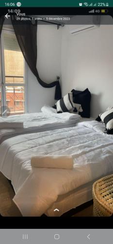 een slaapkamer met een groot wit bed en een raam bij Hyper centre in Marrakesh