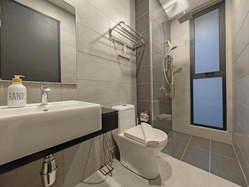 a bathroom with a sink and a toilet and a window at Cityscape Haven - Urban Suites by Ocean Luxe in Jelutong