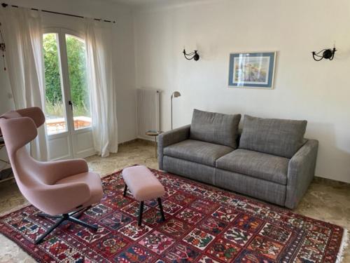 Villa Berta في سانت رافائيل: غرفة معيشة مع أريكة وكرسي