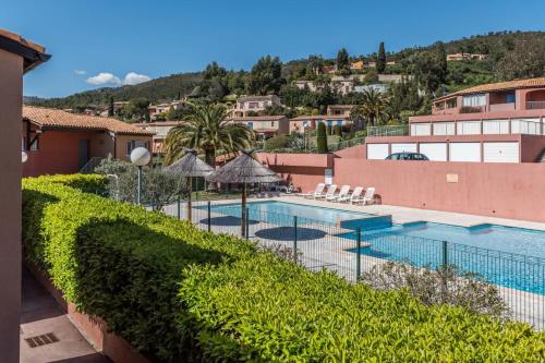 une vue sur la piscine d'un complexe hôtelier dans l'établissement Hübsch eingerichtetes Apartment Miramar mit großem Balkon, Pool, fussläufig zum Strand, à Théoule-sur-Mer